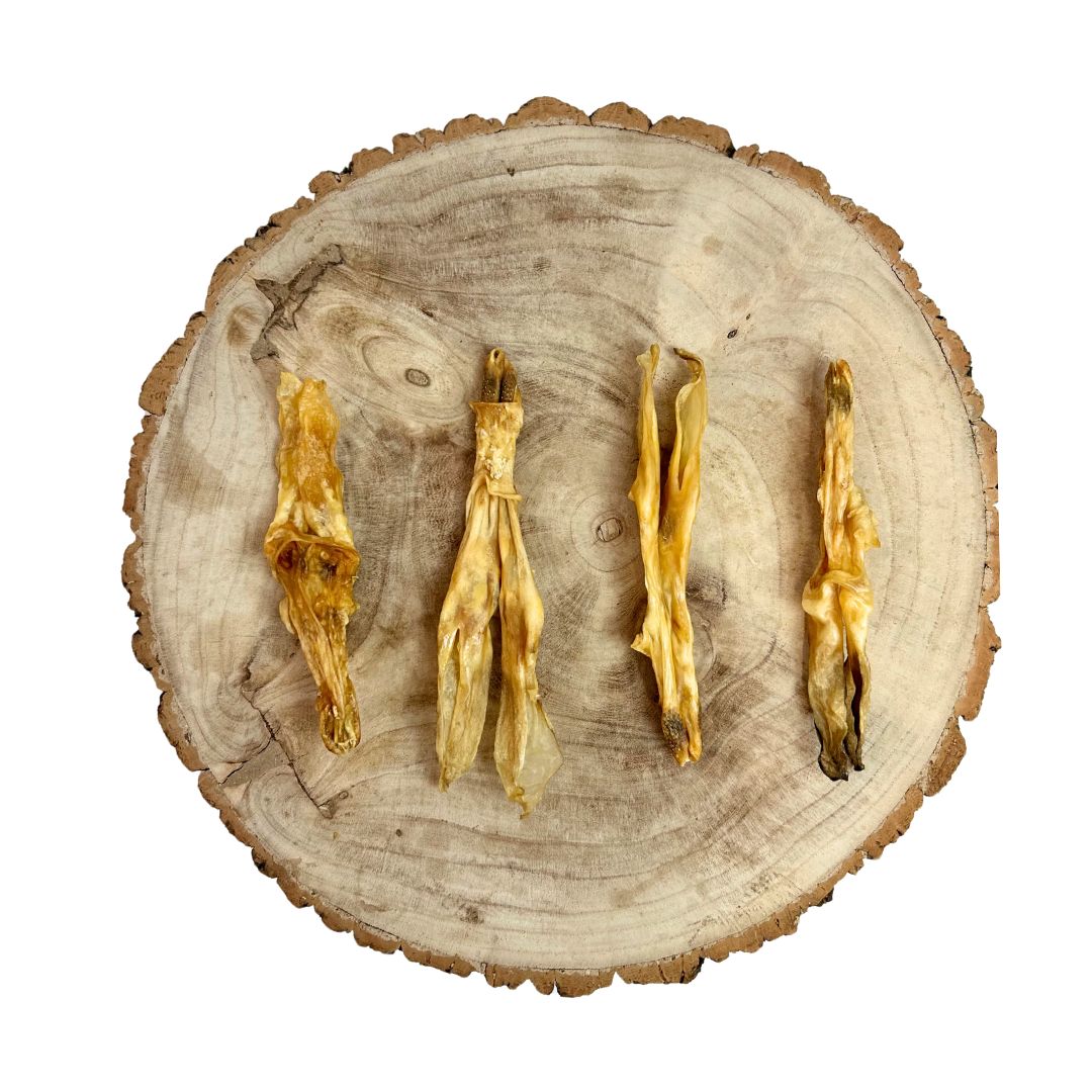 Four dried rabbit ears with no hair on a wooden surface