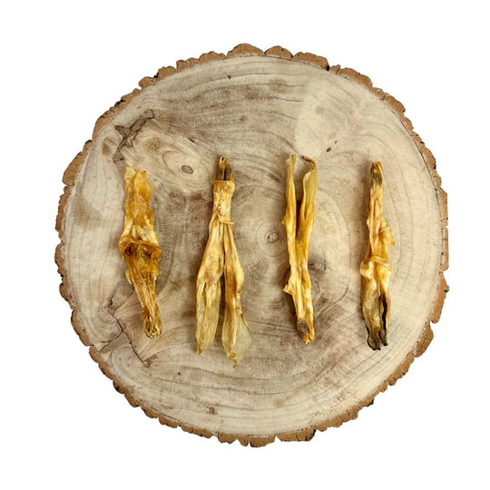 Four dried rabbit ears with no hair on a wooden surface