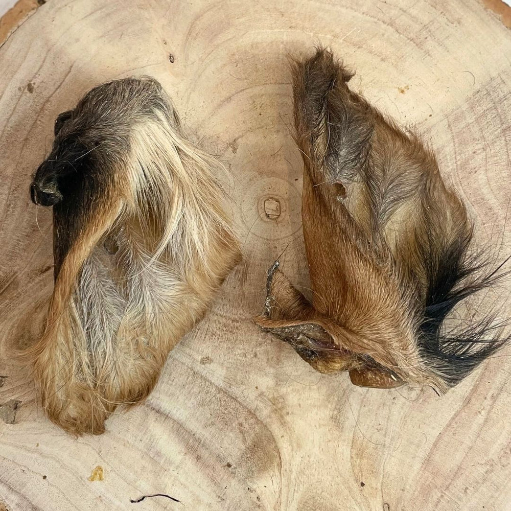 Hairy cow ears dog treats on a wooden board