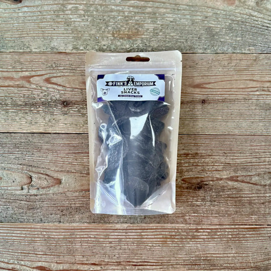 Packaged liver snacks for dogs on a wooden surface