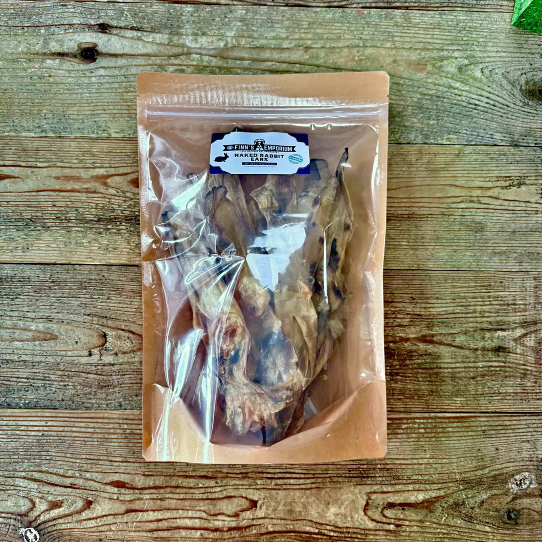 Package of dried rabbit ear dog chews on a wooden surface