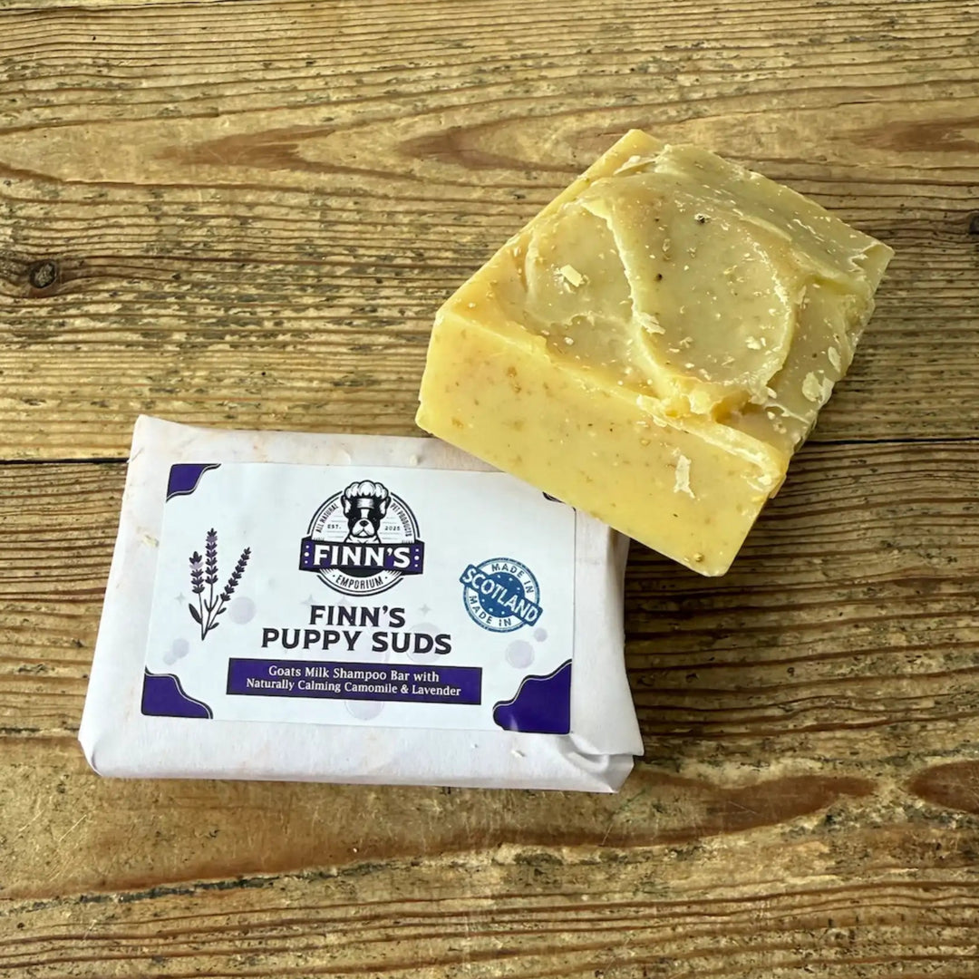 Bar of soap and packaging labeled 'Finn's Puppy Suds' on a wooden surface